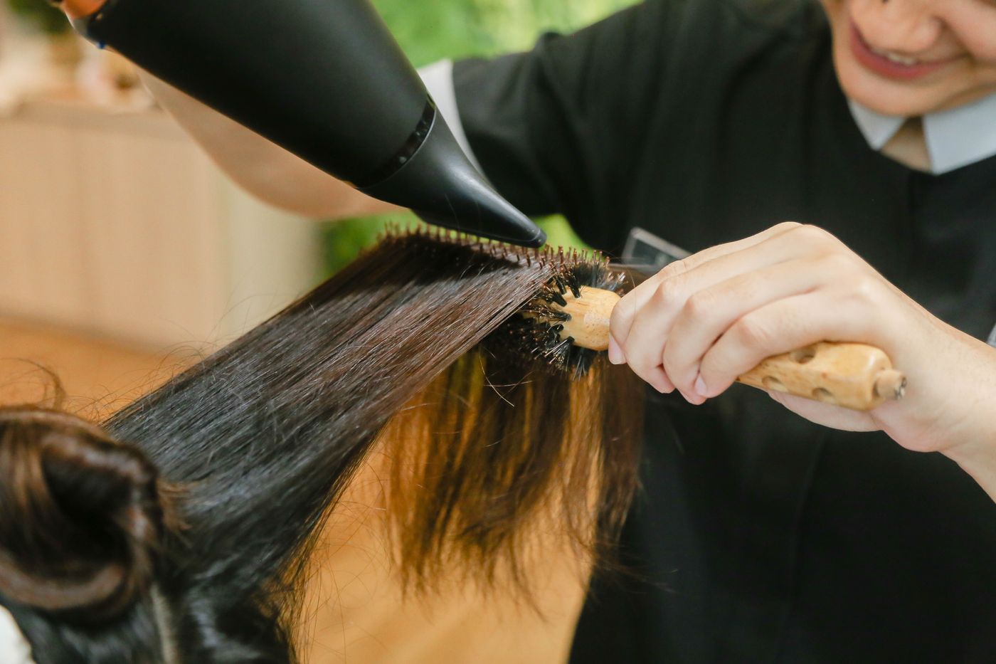Brosse ronde et sèche-cheveux sur des mèches brunes